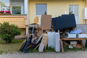 A junk pile in the front of a Salem home. Call or contact Mike & Dad's Hauling if you have unwanted junk removal needs.